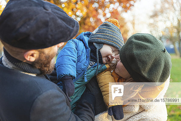Glückliches liebevolles Paar mit kleinem Sohn im Park
