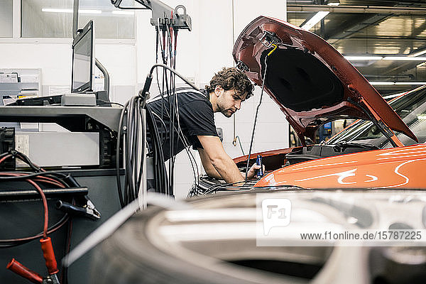 Automechaniker in einer Werkstatt bei der Arbeit am Auto