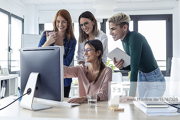 Five businesswomen using pc in an office