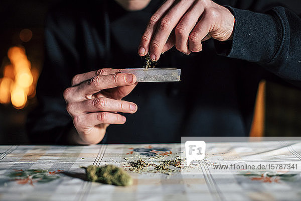 Close-up of a man's hands preparing marihuana joint