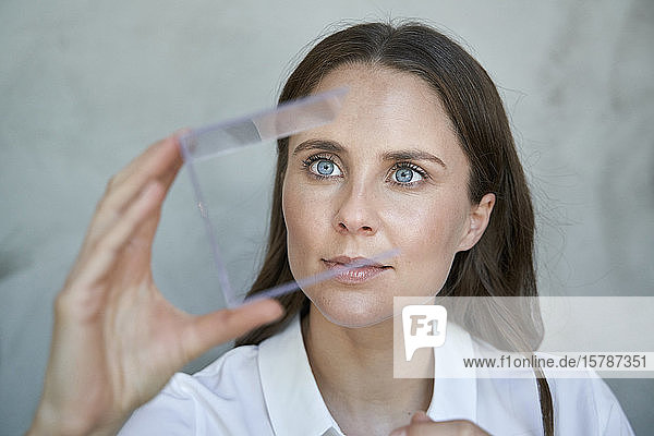 Porträt einer Frau die einen transparenten Würfel betrachtet