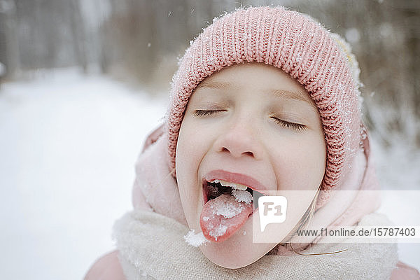 Porträt eines Mädchens mit geschlossenen Augen  das Schnee schmeckt