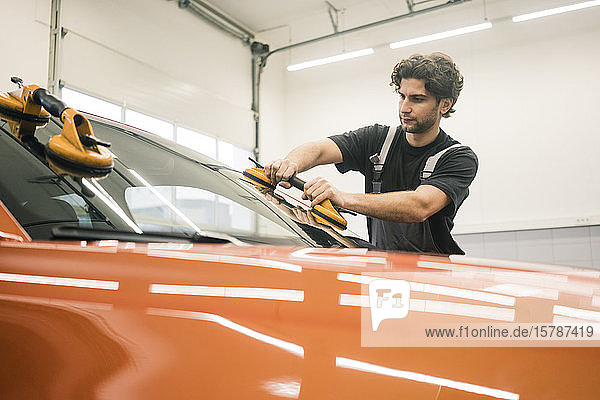 Automechaniker in einer Werkstatt beim Fensterwechsel