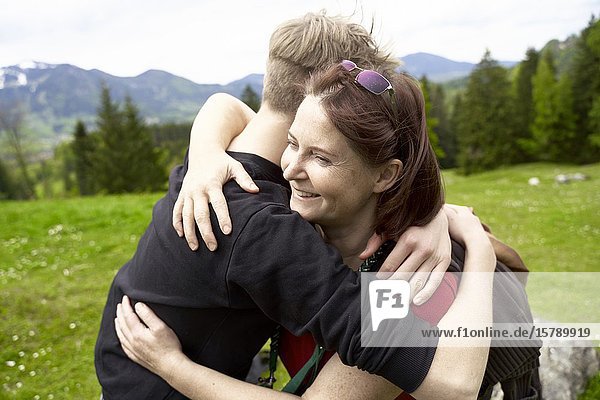 Mature woman and teenager son in the countryside  embracing. Bad Tölz  Upper bavaria  Germany.