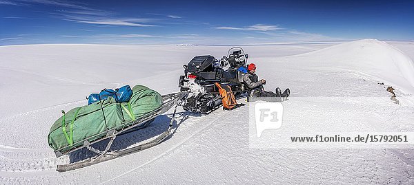 Scientist with snowmobiles on a glacial trip to take samples and measurements  Vatnajokull Ice Cap  Vatnajokull National Park  Iceland.