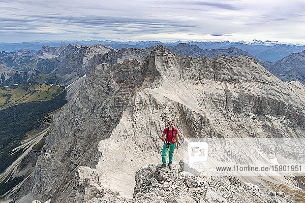 Frau steht auf Felsen und schaut in die Kamera  Blick von der Birkkarspitze  Karwendeltal  Tirol  Österreich  Europa