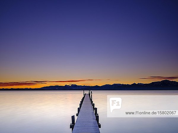 Steg am Chiemsee bei Morgendämmerung hinten die Chiemgauer Alpen Chiemgau Oberbayern Bayern Deutschland Europa
