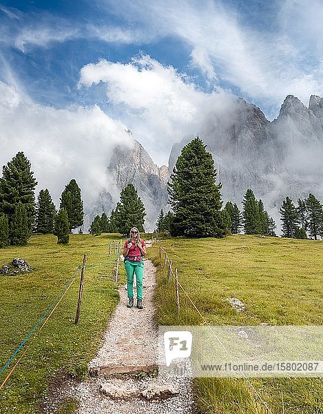 Young woman  hiker on a hiking trail  in the back Sass Rigais  Parco Naturale Puez Odle  South Tyrol  Italy  Europe