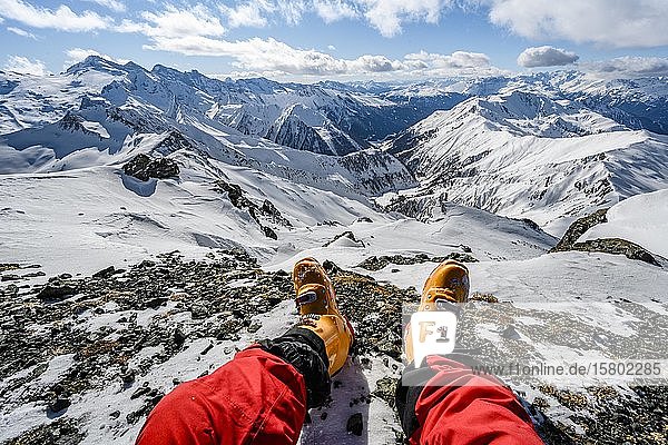 Blick vom Gipfel der Geierspitze  Beine mit Skischuhen vor verschneitem Bergpanorama  Wattentaler Lizum  Tuxer Alpen  Tirol  Österreich  Europa