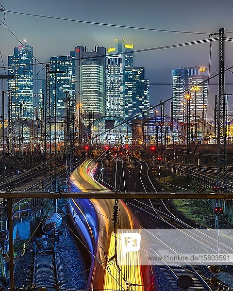 Fahrender Zug vor dem Hauptbahnhof Frankfurt am Main vor der Skyline  bunt beleuchtet  Frankfurt  Hessen  Deutschland  Europa