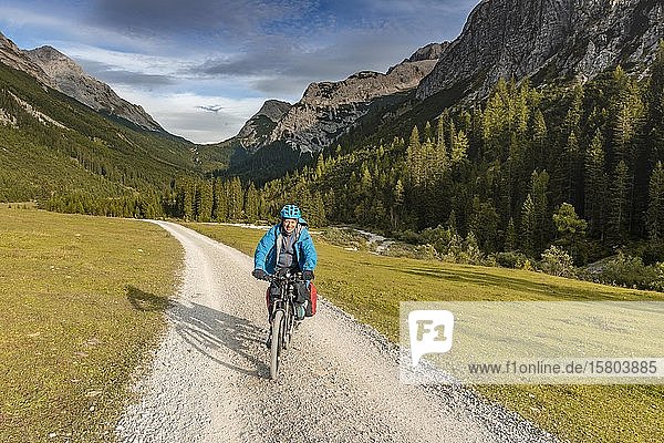 Cyclist  mountain biker bikes on gravel road  Karwendeltal  way to the Karwendelhaus  Tyrol  Austria  Europe