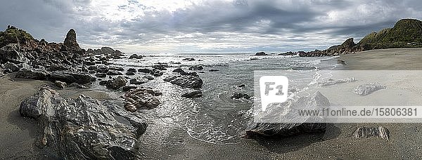 Rocky coast  rocks on the beach  dark rain clouds  long time exposure  West Coast  South Island  New Zealand  Oceania
