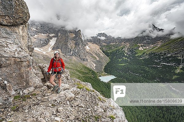 Young woman  hiker on a fixed rope route  Via ferrata Vandelli  Sorapiss circuit  mountains with low clouds  Dolomites  Belluno  Italy  Europe