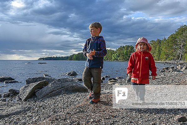 Kleines Mädchen und Junge spielen im Freien an einem See  Norwegen  Europa