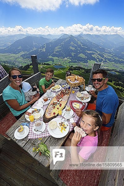 Family eating a snack at the Salvenalm Hohe Salve Hopfgarten Brixental Kitzbühel Alps Tyrol Austria Europe