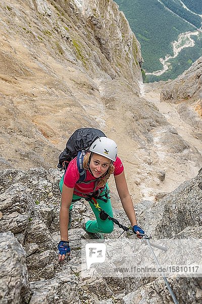 Junge Frau  Wanderin auf einem Klettersteig  gesichert an einem Stahlseil  zwischen Felsen  Via ferrata Francesco Berti  Sorapiss Rundweg  Dolomiten  Belluno  Italien  Europa