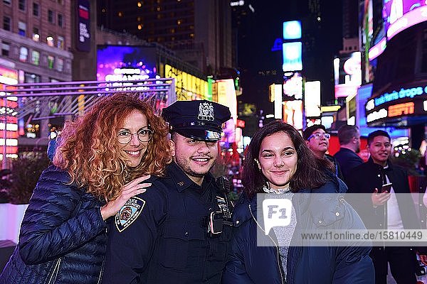 Policeman has his picture taken with tourists in Times Square Manhattan New York City New York State USA North America