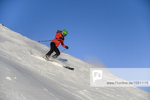 Skier descending steep slope  black piste  blue sky  SkiWelt Wilder Kaiser  Brixen im Thale  Tyrol  Austria  Europe