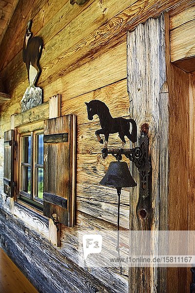 Small Swiss stone pine hut next to the mountain inn Streichen with bell made of wrought iron Schleching Chiemgau Upper Bavaria Bavaria Germany Europe