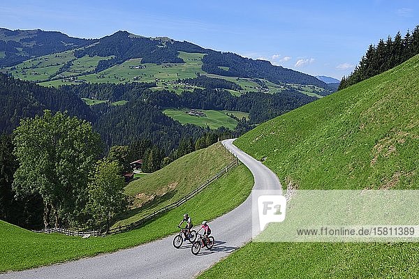Zwei Radfahrer mit Elektro-Mountainbikes auf dem Glantersberg mit Blick auf die Hohe Salve  Kitzbüheler Alpen  Tirol  Österreich  Europa