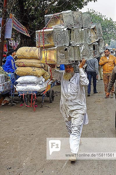 Mann trägt Dosen auf dem Kopf  Chandni Chowk Bazar  einer der ältesten Märkte in Alt-Delhi  Indien  Asien