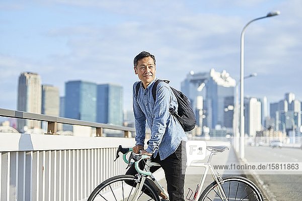 Älterer japanischer Mann mit Fahrrad in der Innenstadt von Osaka  Japan