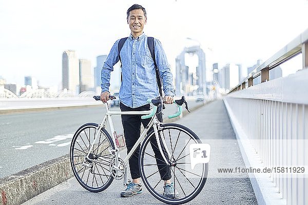 Älterer japanischer Mann mit Fahrrad in der Innenstadt von Osaka  Japan