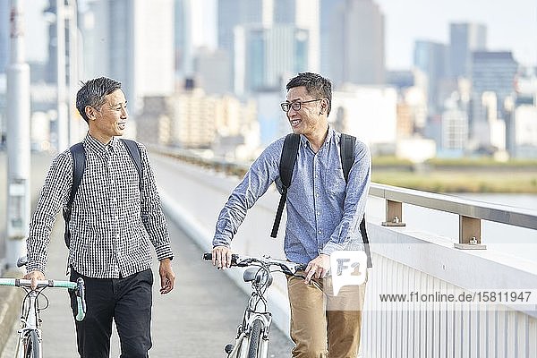 Mature Japanese men with bikes downtown Osaka  Japan