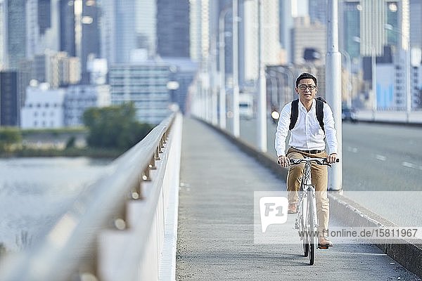Mature Japanese man with bike downtown Osaka Japan