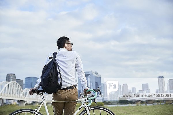 Mature Japanese man with bike downtown Osaka Japan