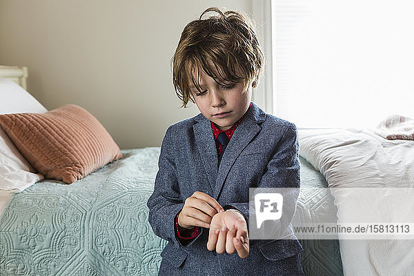 A six year old boy adjusting his watch band