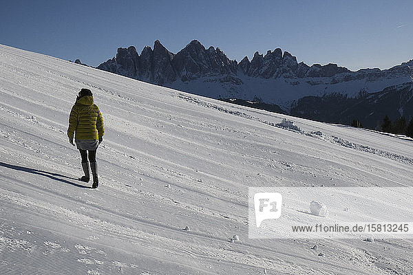 Frau beim Wandern an einem sonnigen  verschneiten Berghang  Brixen  Südtirol  Italien