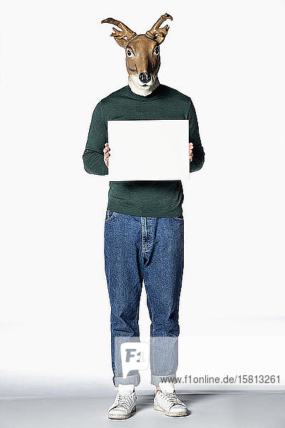 Man in reindeer mask holding blank sign
