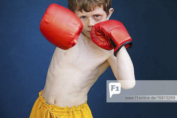 Porträt harter Junge mit blauem Auge und Boxhandschuhen in Kampfhaltung