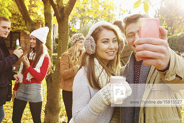 Glückliches Teenager-Paar macht Selfie mit Smartphone im Herbstpark