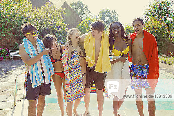 Porträt glückliche Teenager-Freunde am sonnigen Sommerpool