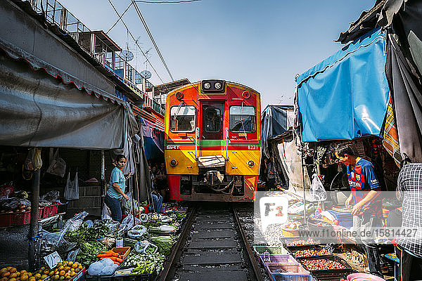 Zug  der durch den Maeklong Railway Market fährt  Bangkok  Thailand  Südostasien  Asien