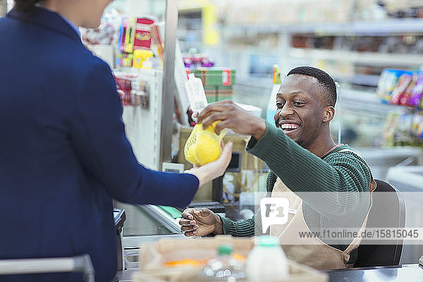 Kassiererin hilft Kunden an der Supermarktkasse