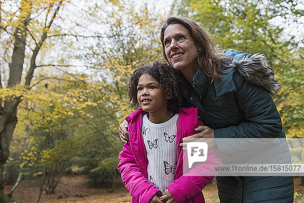 Neugierige Mutter und Tochter im Herbstwald