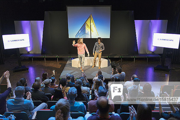 Audience clapping for photographers on stage