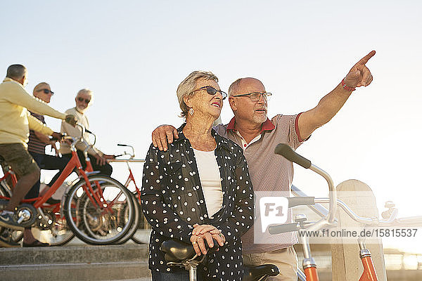 Aktives älteres Touristenpaar mit Fahrrädern und Blick auf die Landschaft