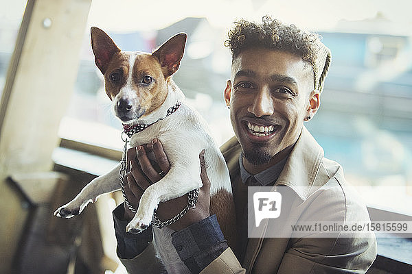 Porträt lächelnder junger Mann mit Hund