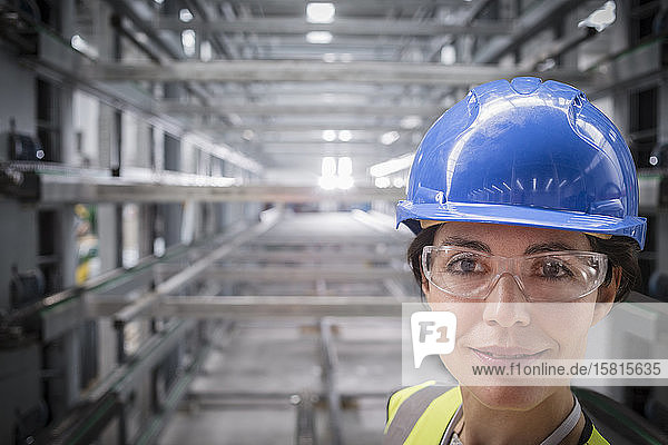 Porträt einer selbstbewussten  lächelnden Arbeiterin in einer Stahlfabrik