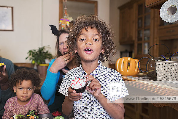 Porträt Junge isst Halloween-Cupcake