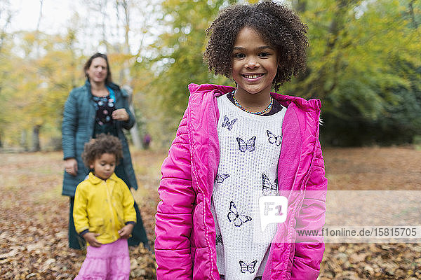 Portrait happy girl with family in autumn woods