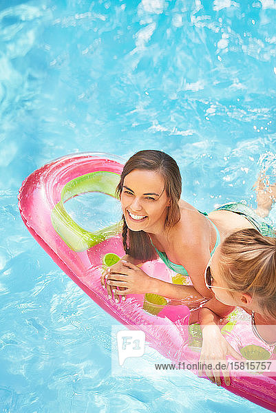 Portrait lächelnd Frauen Freunde schwimmend auf Pool Floß im Sommer Schwimmbad