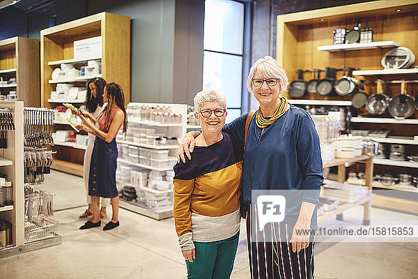 Porträt glücklicher älterer Frauen  die in einem Haushaltswarengeschäft einkaufen