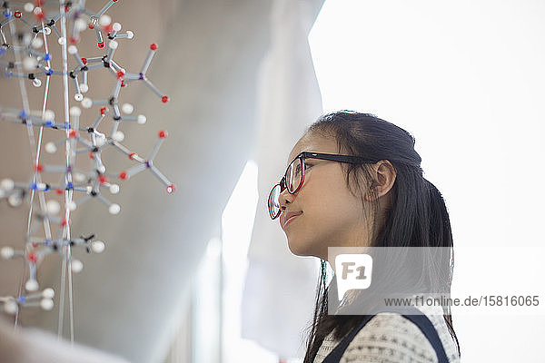 Nachdenkliche,  neugierige Schülerin,  die die Molekularstruktur untersucht