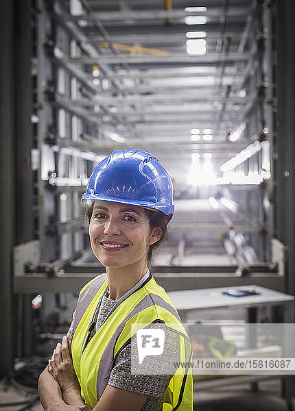 Porträt einer lächelnden  selbstbewussten Arbeiterin in einer Stahlfabrik