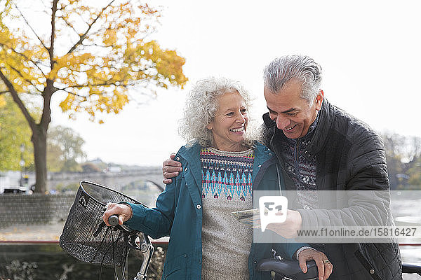 Abenteuerlustiges älteres Ehepaar mit Fahrrädern schaut auf die Karte